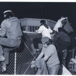 AIM Members climb over a fence to occupy the Naval Air Station in Minneapolis