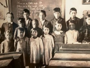 black and white photograph of American Indian students in a school room.