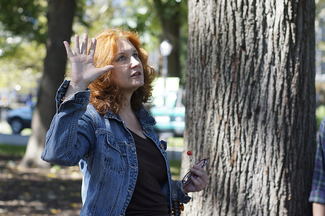 Karen Finley standing by a tree