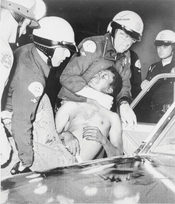 White cops detaining a black man during the Watts Riots