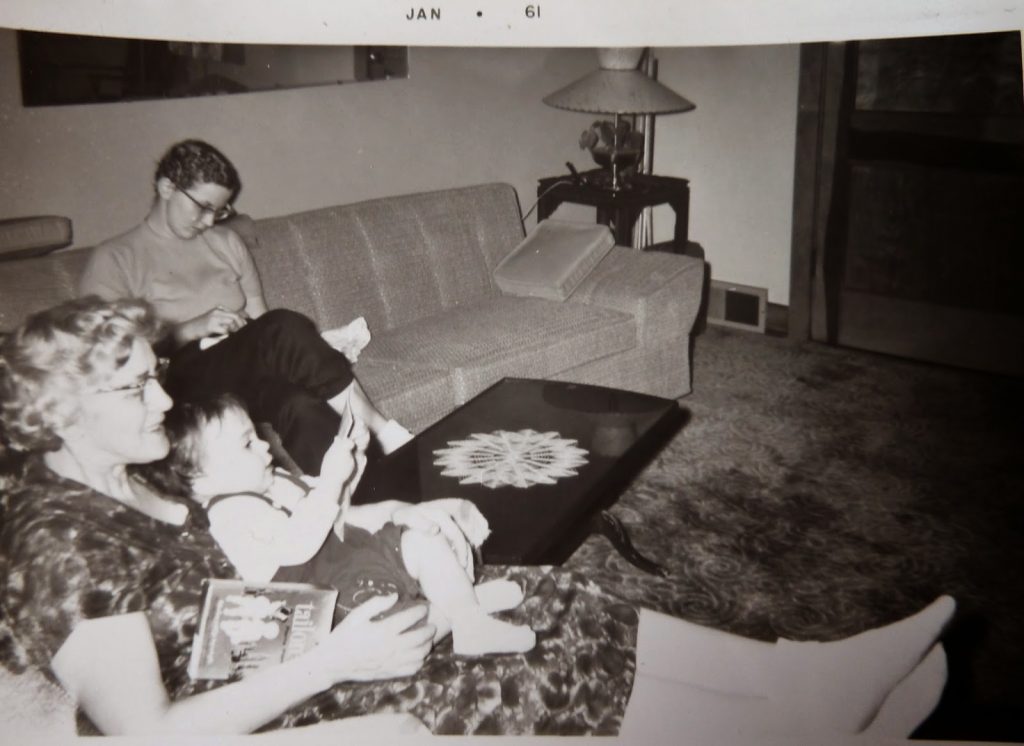 1 year old me on Auntie's lap, my mother in the background