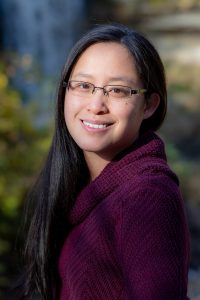 Jocelyn Leung smiling, looking at the camera and wearing a maroon sweater