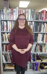 Photograph of Shelly Finzen, librarian at the Tyler Public Library, in front of a range of books.