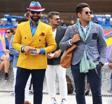 A group of fashion forward young men, dressed in trendy clothes, sunglasses and other accessories.