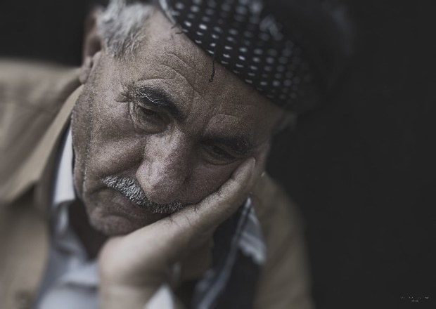 Older man resting his head in his hand.