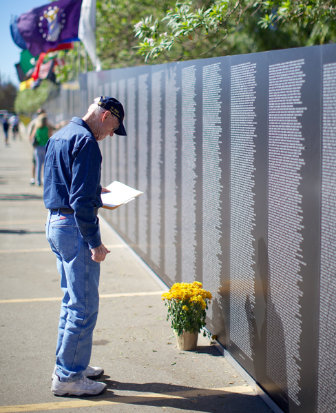 A person leaving flowers at the Vietnam Veteran War Memorial