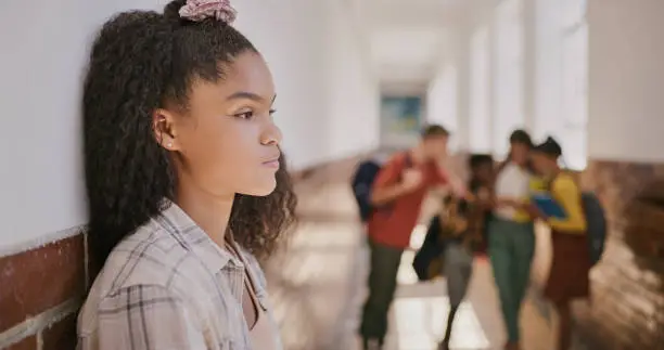 A child looking at other people while standing alone