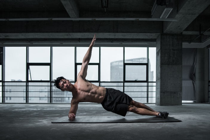 Young man in great physical condition doing a side plank.