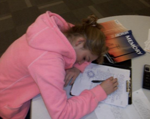 Female adolescent sleeping on her textbooks.