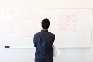man looking at whiteboard of math problems