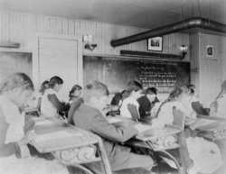 “Intermediate” students inside a classroom at a Native American boarding school in Beaulieu, Minnesota, c.1900.