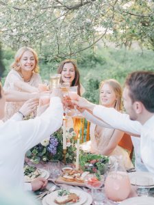 Friends toasting each other on a picnic.