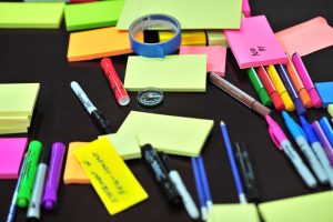 Ornamental photo of markers and post it note pads to communicate order and study