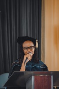 woman at a graduation speaking in a microphone