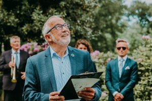 man giving a speech outside at a wedding.